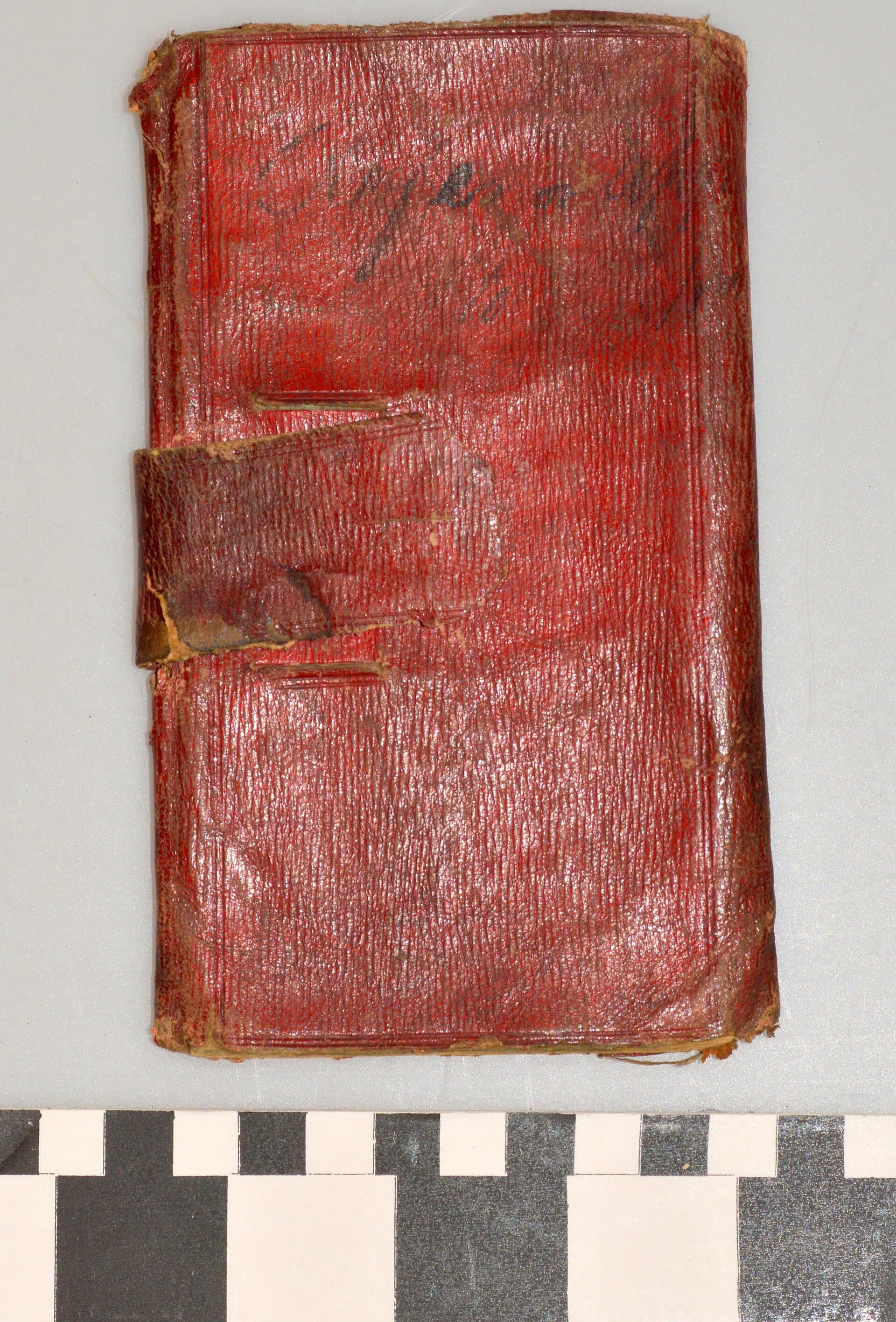 A worn red leather notebook photographed from above
